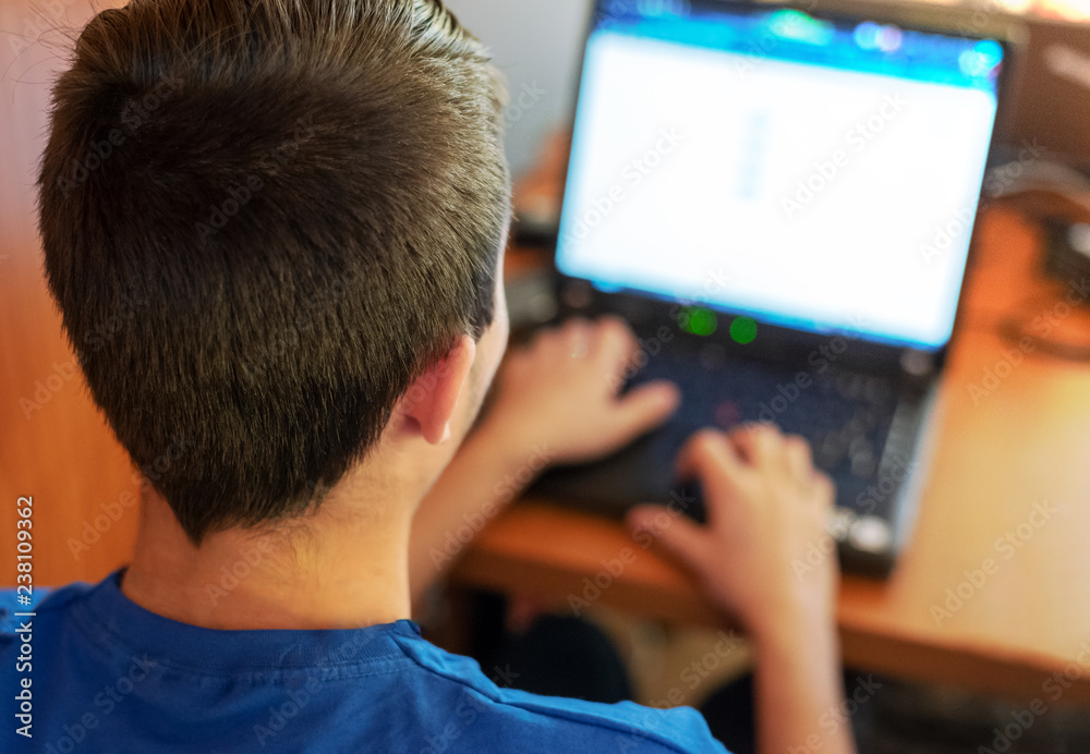 Young man programming on a laptop Young man programming on a laptop