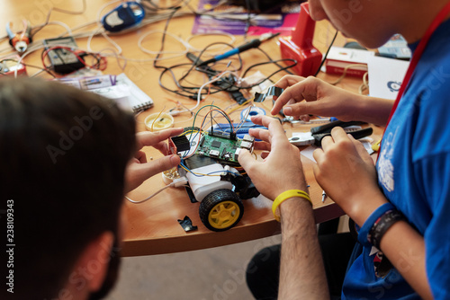 Boy and his mentor working on a self made computer controlled vehicle
