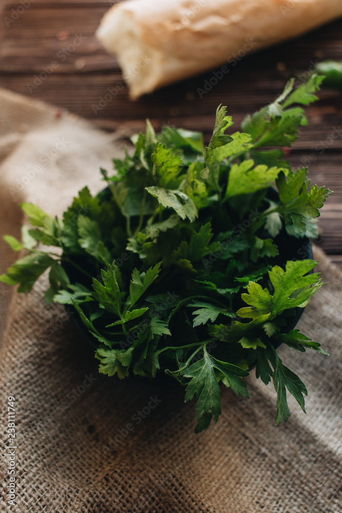 Bunch of fresh green parsley twigs on wooden background Bunch of fresh green parsley twigs on wooden background
