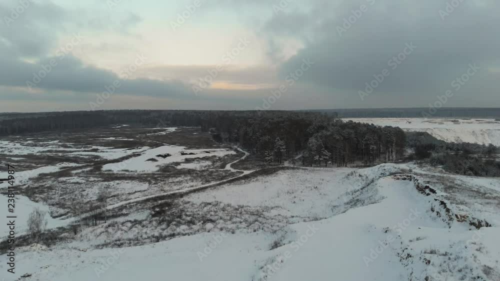 Winter landscape in cloudy weather. Forest and field in winter on video from the air. Aerial view. 4k drone flight Winter landscape in cloudy weather. Forest and field in winter on video from the air. Aerial view. 4k drone flight