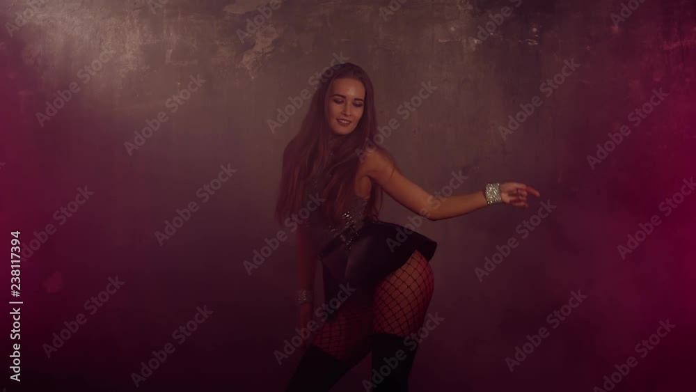 Charming young woman is dancing go-go style in dark dance floor. She is smiling broadly and playfully, showing her amazing body. Shoot with RED RAVEN camera. Charming young woman is dancing go-go style in dark dance floor. She is smiling broadly and playfully, showing her amazing body. Shoot with RED RAVEN camera.