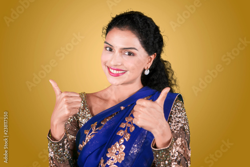Indian woman with saree clothes shows thumbs up