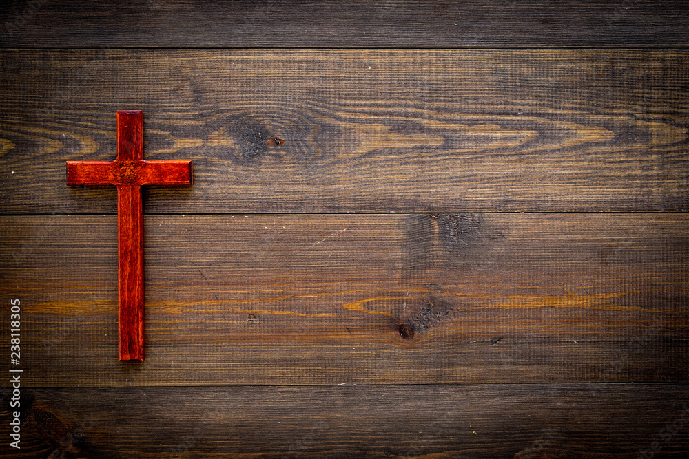 Funeral concept. Wooden cross on dark wooden background top view copy space