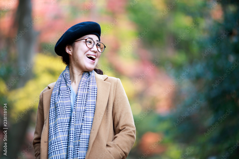 笑顔の女性と紅葉のぼかし背景 笑顔の女性と紅葉のぼかし背景