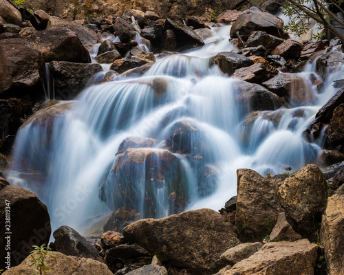 Mountain stream cascade falls over rocks