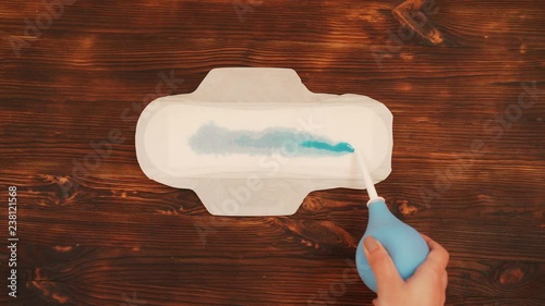 Wallpaper Mural Menstrual pad, on a wooden background, pouring blue liquid. Torontodigital.ca
