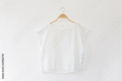 White blouse is clothes hanging on white background.