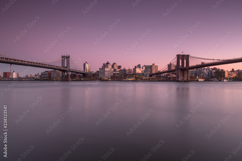 View on Dumbo location with Manhattan Bridge and Brooklyn Bridge from east river at sunset 