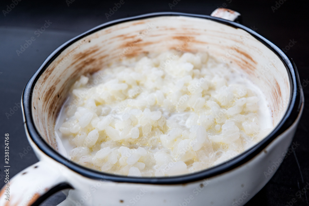 rice pudding in white plate on dark background rice pudding in white plate on dark background