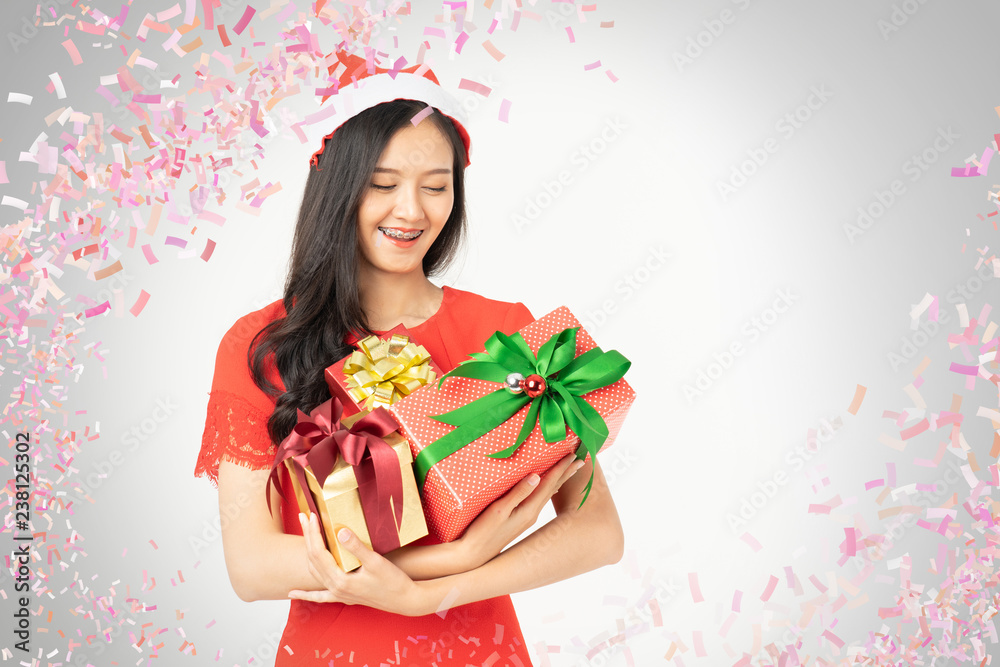 Photo of asian curious woman in red dress rejoicing her birthday or new year gift box. Young woman holding gift  box with red bow being excited and surprised  holiday present isolated white background