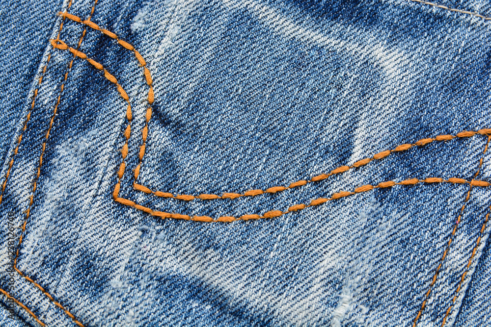 Denim fabric texture with yellow stitching Denim fabric texture with yellow stitching
