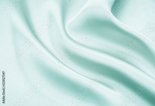 The texture of the satin fabric of green color for the background 