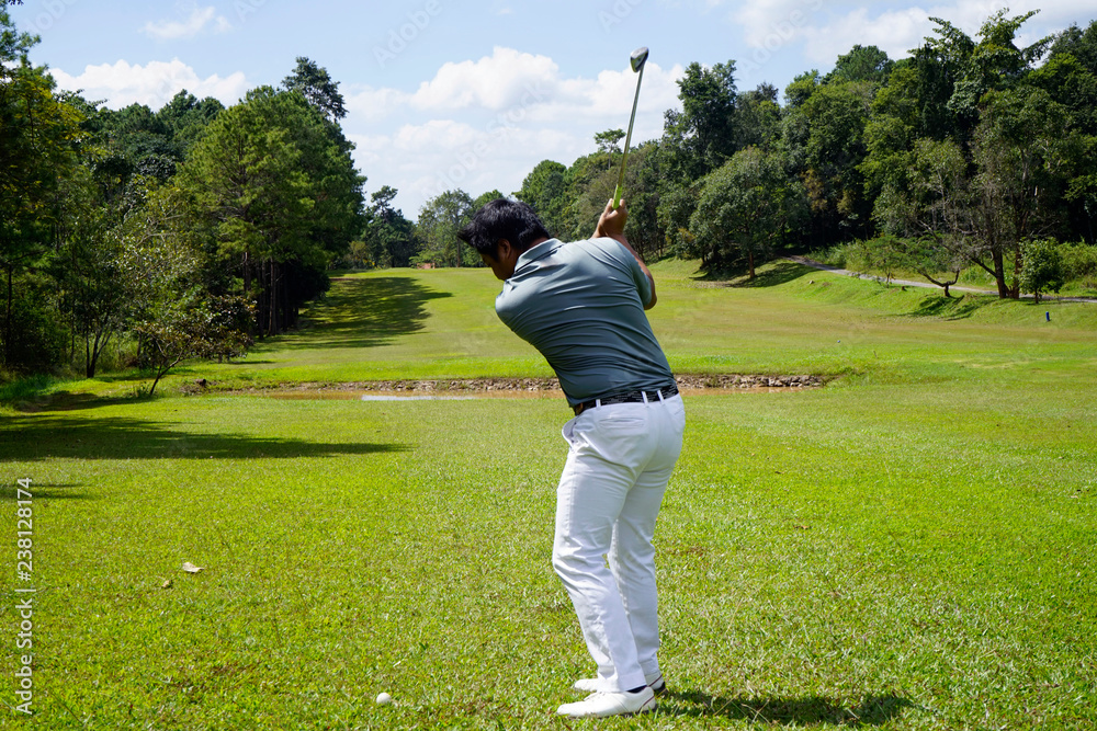 Golfer playing golf in beautiful golf course in the evening golf course with sunshine in thailand Golfer playing golf in beautiful golf course in the evening golf course with sunshine in thailand