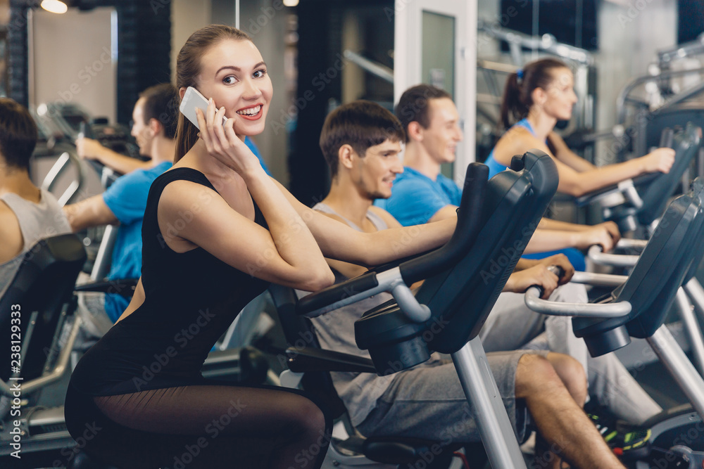 Girl is talking on a mobile phone during a workout Girl is talking on a mobile phone during a workout