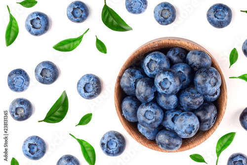 fresh ripe blueberry with leaf in wooden bowl isolated on white background. Top view. Flat lay pattern