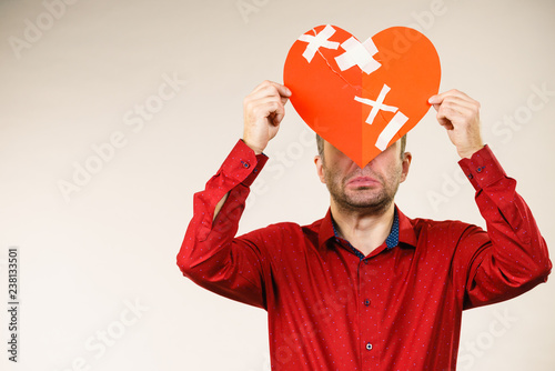 Adult man holding broken heart