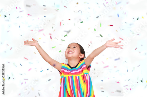 Happy little child girl with colorful confetti on white background. Happy New Year or Congratulation Concept.
