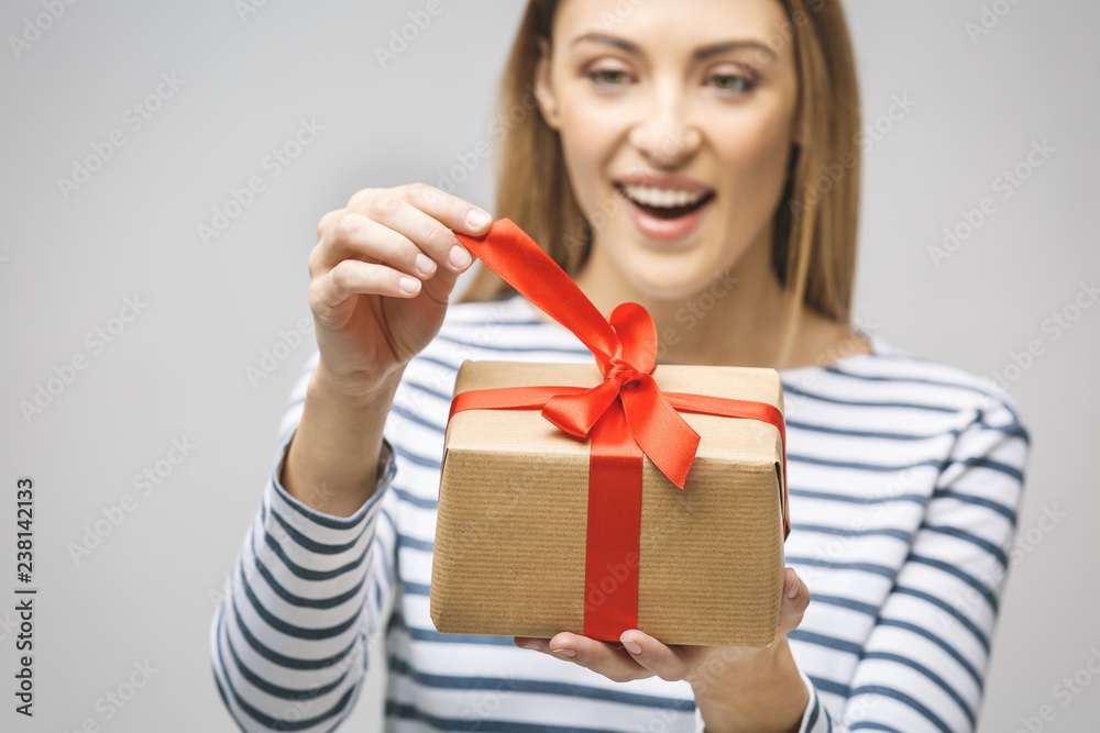 Smiling woman hold gift box isolated over white background. Portrait of a joyful young woman dressed in casual, holding gift box and celebrating. Smiling woman hold gift box isolated over white background. Portrait of a joyful young woman dressed in casual, holding gift box and celebrating.