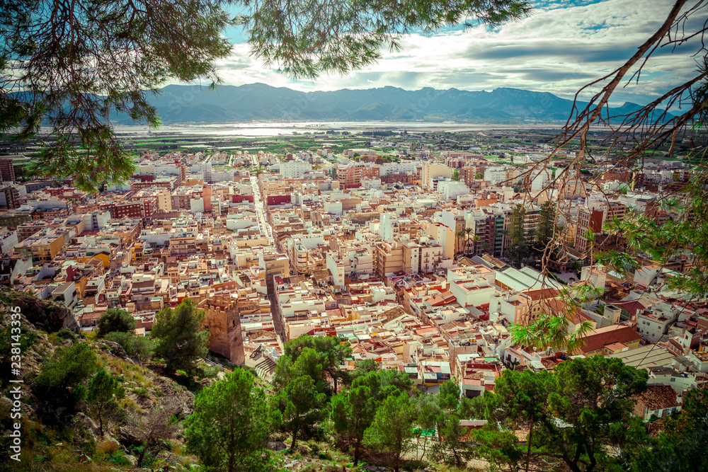 Breathtaking panoramic view from a hill on vacation area of Cullera, Valencian community, Spain. Showing the old city, castle tower, mountains, river and forest.