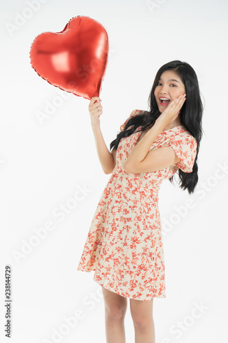 Asian young woman in red dress  red ballon heart. Young woman holding it with  being excited and surprised  holiday present isolated white  background.concept love surprise valentine day. © anon