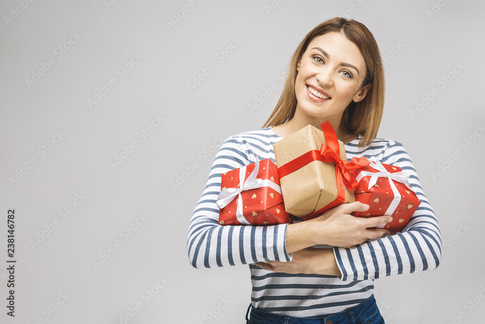 Nice surprise! Happy brunette woman holding big pile of gifts. Isolated over white background. Nice surprise! Happy brunette woman holding big pile of gifts. Isolated over white background.