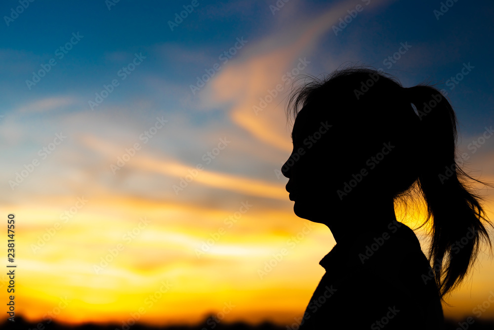 Silhouette woman standing sad in the sunset.