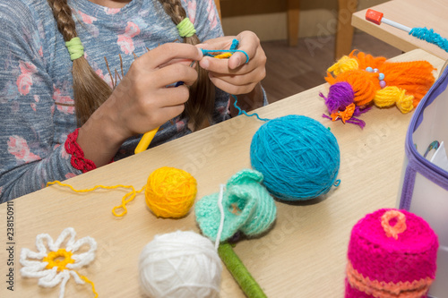 The girl is engaged in needlework in the classroom