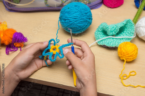 The girl knits a flower from thread, close-up