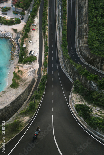 Inception photo landscape. Motorbike go on the road, shoot from a drone