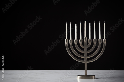 Metal Hanukkah Menorah With Unlit Candles On Marble Surface Against Black Studio Background