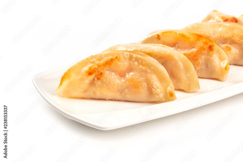 A closeup photo of gyozas, Asian dumplings, on a white background with a place for text