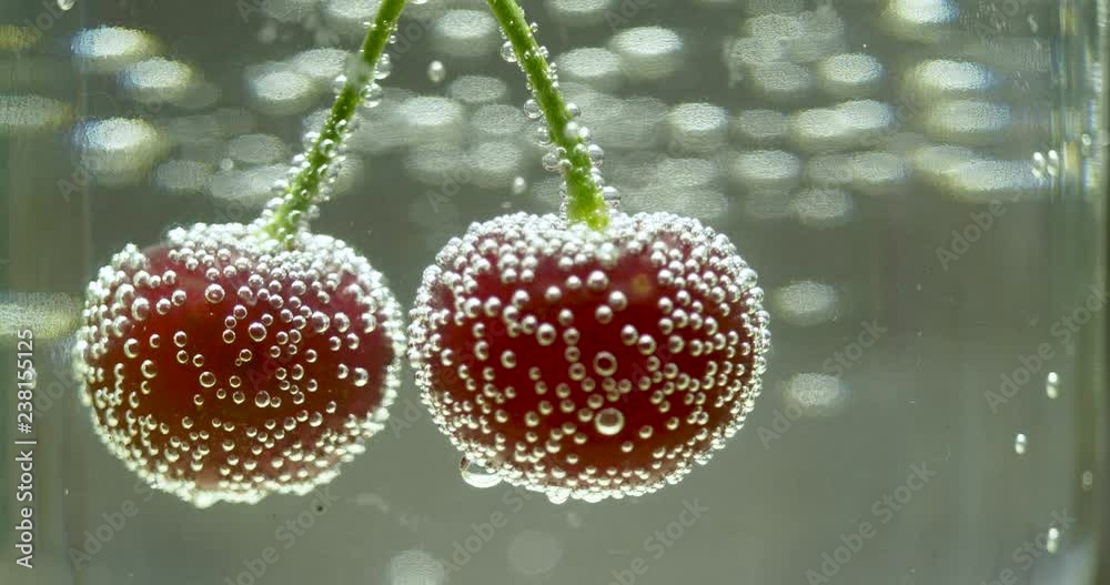 double cherry in glass of water with bubbles double cherry in glass of water with bubbles