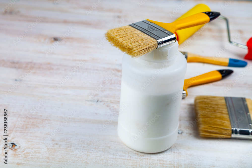 Paint can, roller and brush on the table. Paint can, roller and brush on the table.