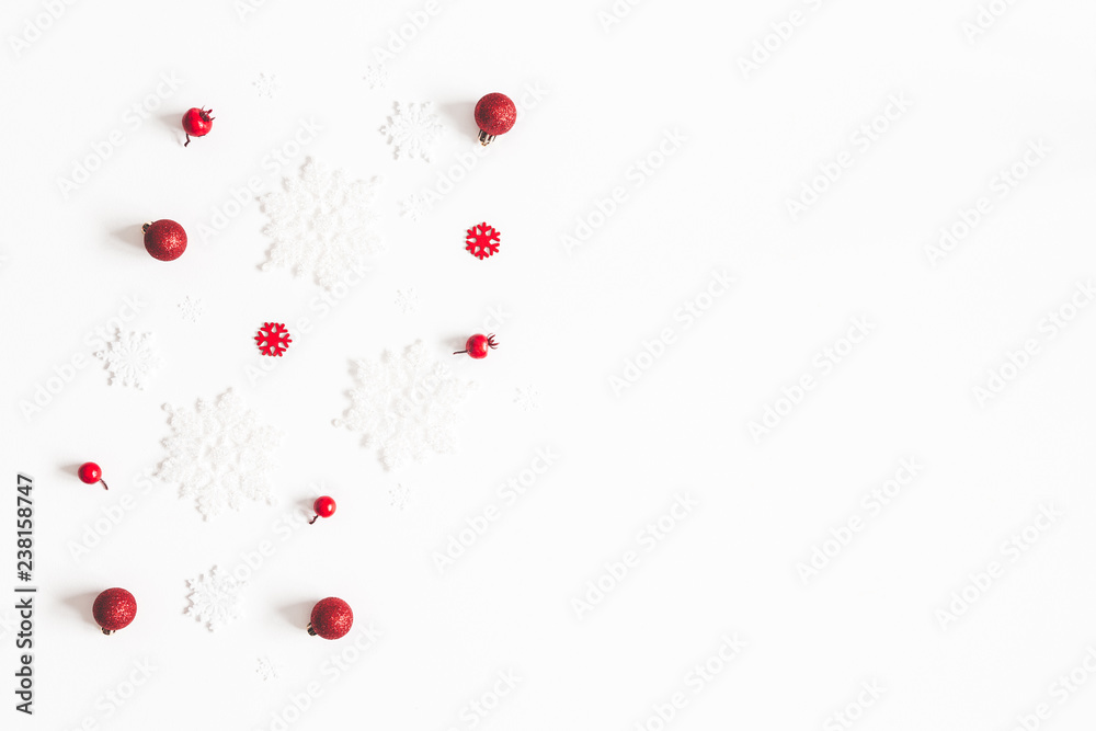 Christmas composition. Frame made of snowflakes, red decorations on white background. Christmas, winter, new year concept. Flat lay, top view, copy space