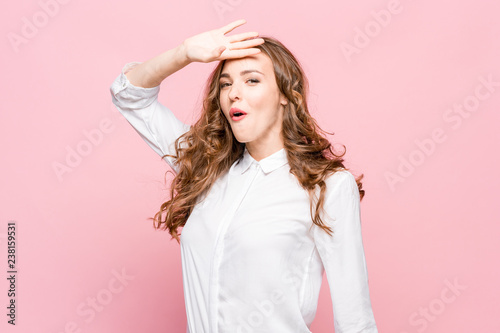 The young woman's portrait with happy emotions on pink background