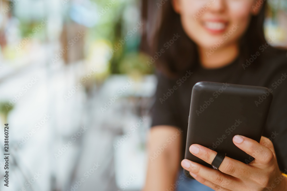 Woman hand using smartphone and laptop with cafe shop sunlight shade to object beautiful background. Woman hand using smartphone and laptop with cafe shop sunlight shade to object beautiful background.