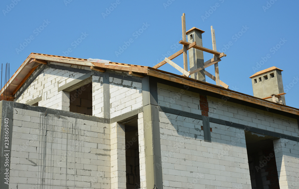 House construction site with roofing and installing chimney House construction site with roofing and installing chimney