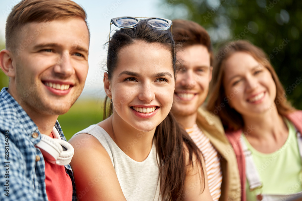 Fototapeta premium leisure, people and friendship concept - happy teenage friends outdoors in summer