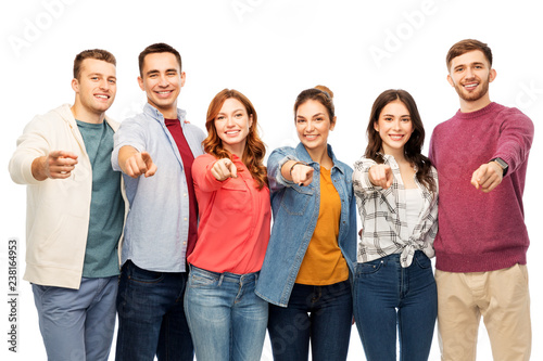 friendship and people concept - group of smiling friends pointing at you over white background
