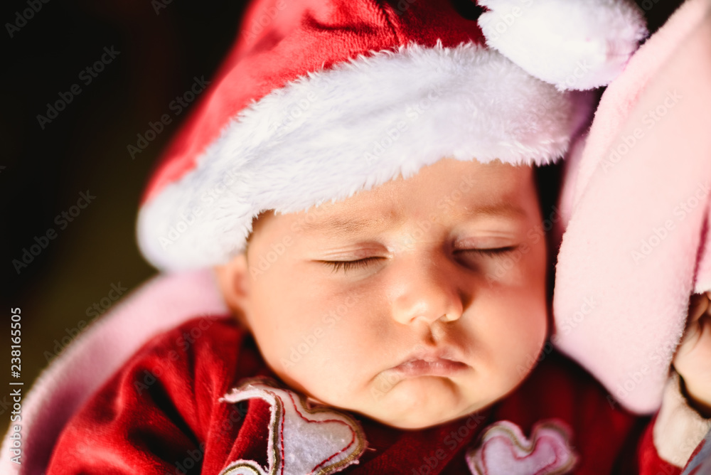 Newborn girl asleep with a Santa Claus hat Newborn girl asleep with a Santa Claus hat