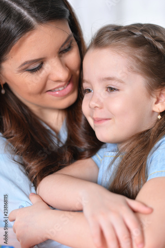 Close up portrait of cute little girl with mother hugging