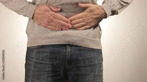 Man holding his stomach in pain. Men problems on white background. Medical concept photo