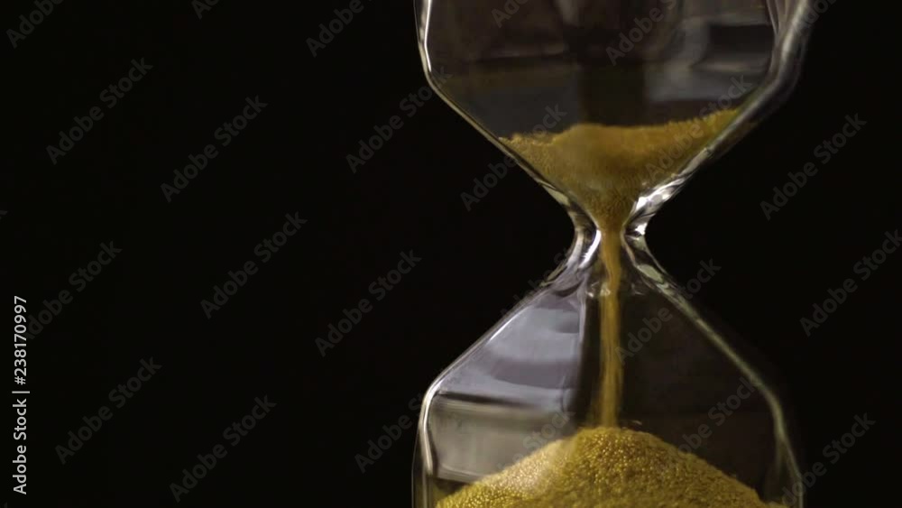 4k slow motion ,The sand flow in the hourglass with black background
