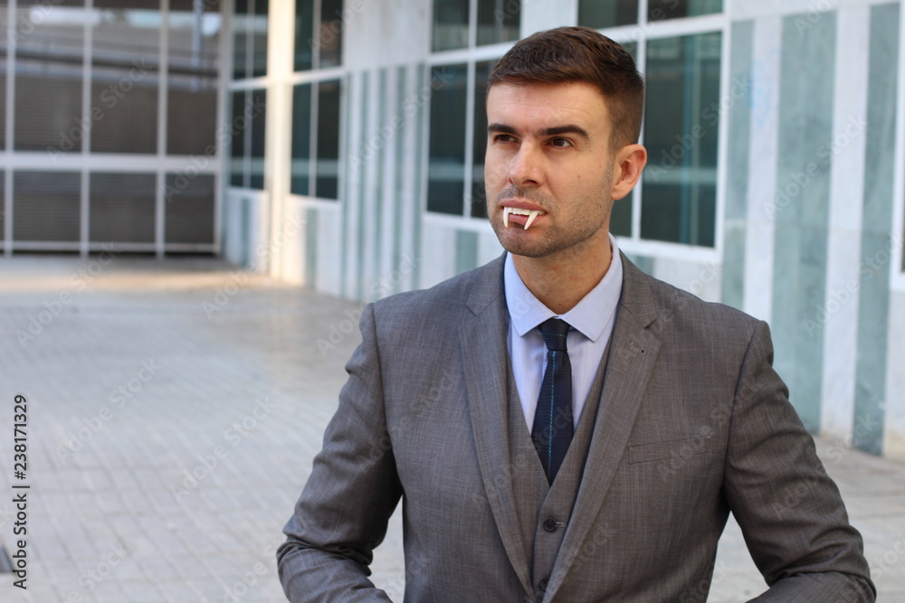 Businessman with vampire fangs in the office Businessman with vampire fangs in the office