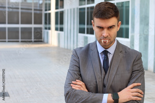 Businessman with vampire fangs in the office