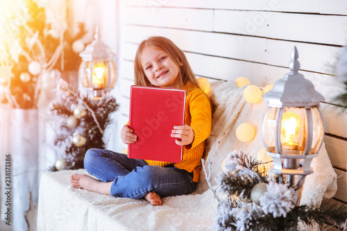 Girl with a book on the background of the Christmas background photo