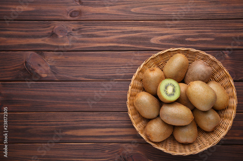 Kiwi in a basket on brown background photo