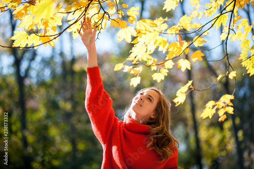 Natural woman in autumn scenery surrounded by colorful leaves