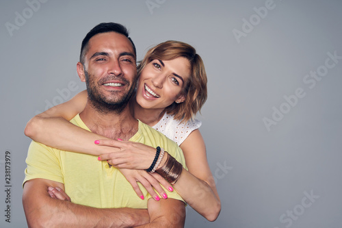 Happy couple in studio laughing over grey
