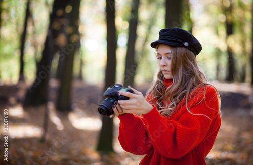 Young woman having fun with camera making photos at green park © leszekglasner